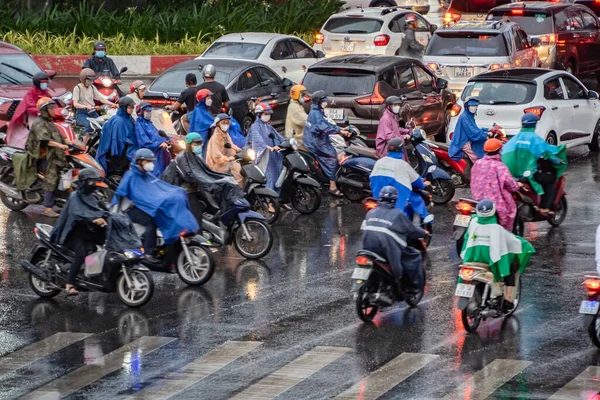 越南胡志明 2023年4月24日 越南加冕人戴头盔和雨衣 在大雨和交通阻塞中骑摩托车 这次是在越南西贡的雨季 — 图库照片