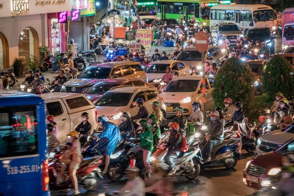 stock image Ho Chi Minh, Viet Nam - 24 April 2023: Vietnamese crowned people with rush hour in heavy rain and traffic jam. This time is rainy season at Saigon, Vietnam