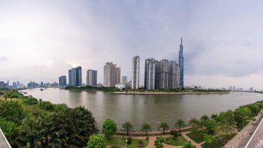 Ho Chi Minh, Viet Nam - 28 Nisan 2023: Landmark 81 'de günbatımı manzarası - Saigon Nehri boyunca uzanan inşaat binaları ile süper uzun bir gökdelen ve Saigon köprüsü