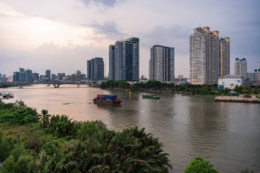 Ho Chi Minh, Viet Nam - 28 Nisan 2023: Landmark 81 'de günbatımı manzarası - Saigon Nehri boyunca uzanan inşaat binaları ile süper uzun bir gökdelen ve Saigon köprüsü