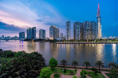 Ho Chi Minh, Viet Nam - 28 Nisan 2023: Landmark 81 'de gece görüşü - Saigon Nehri boyunca uzanan inşaat binaları ile süper uzun bir gökdelen ve Saigon köprüsü