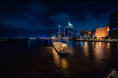 Ho Chi Minh, Viet Nam - 3 Ağustos 2023 Ho Chi Minh City silueti ve Saigon Nehri. Şehir merkezindeki gökdelen ve diğer modern binaların inanılmaz renkli gece manzarası. Seyahat kavramı