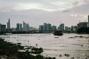Ho Chi Minh, Viet Nam - 12 Temmuz 2023: Ho Chi Minh City silueti ve günbatımında Saigon Nehri. Ho Chi Minh Şehri Vietnam 'ın popüler bir turizm merkezidir..