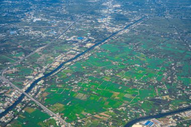 Havaalanına yaklaşırken Vietnam 'ın kırsal kesiminin penceresinden uçağın manzarasına bakıyordu..
