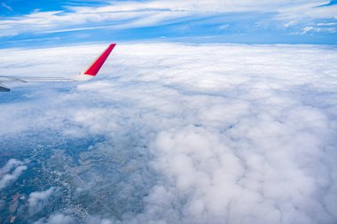 Mavi gökyüzü ve beyaz bulutlu uçak penceresinden bak. Kırmızı uç