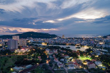 Vung Tau, VIETNAM - 23 Eylül 2023: Vung Tau şehri ve kıyılarında gün batımı, Vietnam. Vung Tau, Güney Vietnam 'da ünlü bir kıyı kentidir. Seyahat kavramı.