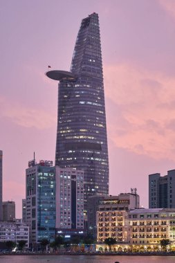 Ho Chi Minh, Viet Nam - 27 Aralık 2023: Ho Chi Minh City silueti ve Saigon Nehri. Şehir merkezindeki gökdelen ve diğer modern binaların inanılmaz renkli gece manzarası. Seyahat kavramı