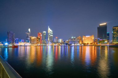 Ho Chi Minh, Viet Nam - 20 Ocak 2024: Ho Chi Minh City silueti ve Saigon Nehri. Şehir merkezindeki gökdelen ve diğer modern binaların inanılmaz renkli gece manzarası. Seyahat kavramı