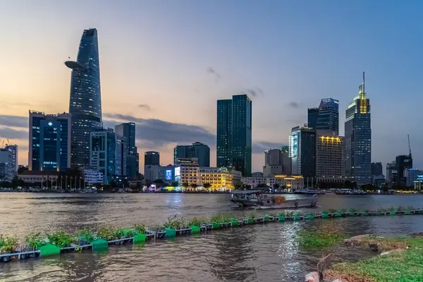 Ho Chi Minh şehri, Vietnam - 28 Şubat 2024 Bitexco Kulesi, binalar, yollar, Bason köprüsü ve Saigon nehri Saigon nehri üzerindeki konteynır kargo gemisi. Seyahat kavramı.