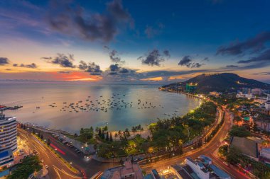 Vung Tau, VIETNAM 3 Mayıs 2024: Güzel günbatımı ve tekneleri olan üst manzara. Vung Tau 'nun yukarıdan panoramik manzarası dalgalar, sahil, sokaklar, hindistan cevizi ağaçları ve Vietnam' daki Tao Phung dağları.