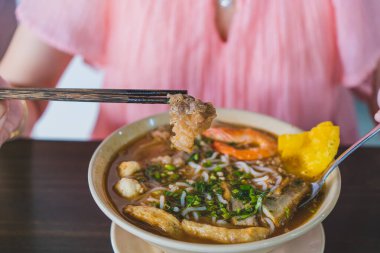 Tom Yum çorbası - Vietnam 'da tahta masada karidesli Tayland çorbası ve pirinç eriştesi