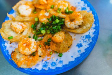 Vietnamese tiny shrimp pancake- Banh Khot Vung Tau. Vietnamese local cuisine. Served with vegetables. Selective focus clipart