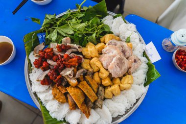 Lezzetli bir Vietnam yemeği olan Bun Dau Mam Tom, haşlanmış et, kızarmış tofu, karides ezmesi ve yeşil sebze, salatalık ve acı biber, limon gibi baharatlarla yapılan popüler bir sokak yemeğidir.