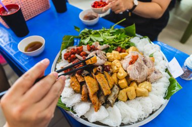 A delicious Vietnamese dish, Bun Dau Mam Tom, is a popular street food made from rice noodles with boiled meat, fried tofu, shrimp paste and green vegetables, cucumber and spices such as chili, lime clipart