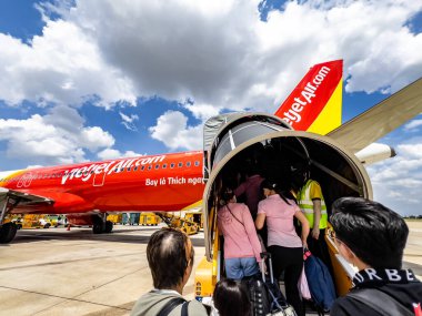 Ho Chi Minh City, Viet Nam - May 25 2024: Passengers queue up to take a flight in Vietjet Air plane at Tan Son Nhat International Airport clipart