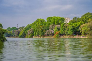 Hanoi, Vietnam - 26 Haziran 2024: Hoan Kiem Gölü veya Kılıç Gölü, Ho Guom Hanoi, Vietnam 'da Kaplumbağa Kulesi ile açık bir günde mavi gökyüzü ve beyaz bulutlar