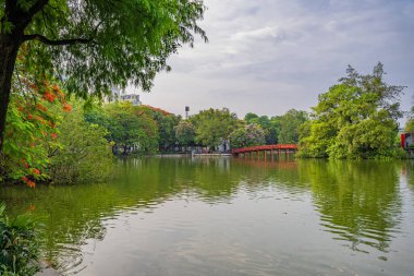 Hanoi, Vietnam - 26 Haziran 2024: Kızıl Huc Köprüsü ve Hoan Kiem Gölü 'nün ortasında Ngoc Son Tapınağı, Hanoi, Vietnam. Vietnam 'ın ünlü hedefi