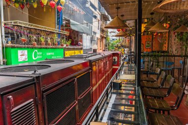 Hanoi, Vietnam - 27 Haziran 2024: Hanoi 'nin Eski Mahallesi' ndeki dar bir sokaktan bir tren geçiyor. Turistler hızlı trenin fotoğraflarını çeker. Hanoi 'nin Tren Sokağı popüler bir turistik merkezdir..