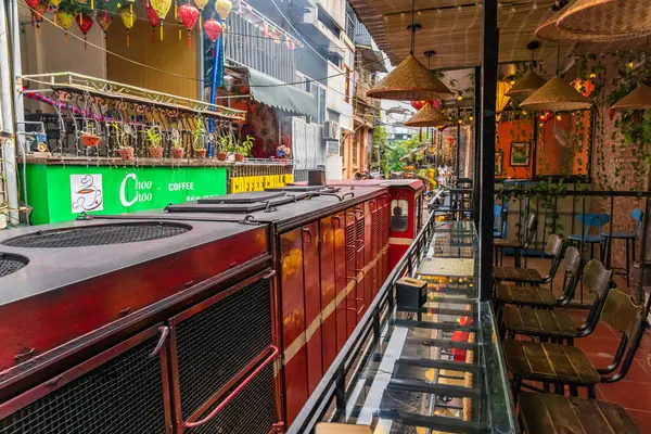 Hanoi, Vietnam - 27 Haziran 2024: Hanoi 'nin Eski Mahallesi' ndeki dar bir sokaktan bir tren geçiyor. Turistler hızlı trenin fotoğraflarını çeker. Hanoi 'nin Tren Sokağı popüler bir turistik merkezdir..
