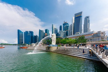 Singapur - 13 Haziran 2024: Merlion Parkı 'ndaki Merlion Fountain ve Singapur şehir silueti sabah mavi gökyüzü ile. Merlion Fountain, Singapur 'un en ünlü turistik yerlerinden biridir. Seyahat kavramı