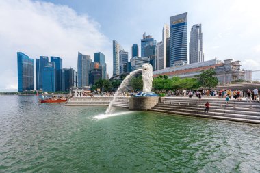 Singapur - 13 Haziran 2024: Merlion Parkı 'ndaki Merlion Fountain ve Singapur şehir silueti sabah mavi gökyüzü ile. Merlion Fountain, Singapur 'un en ünlü turistik yerlerinden biridir. Seyahat kavramı