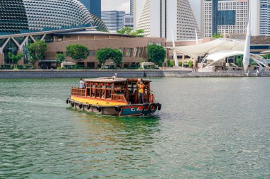 Singapur - 13 Haziran 2024: Arkasında Merlion ve Marina Körfezi silueti olan Singapur Nehri üzerinde Bum Boat gezisi. Seyahat kavramı