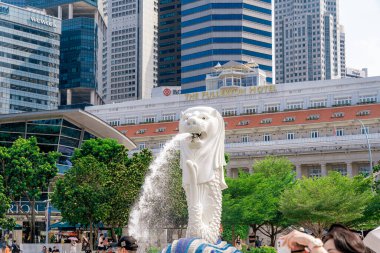 Singapur - 13 Haziran 2024: Merlion Parkı 'ndaki Merlion Fountain ve Singapur şehir silueti sabah mavi gökyüzü ile. Merlion Fountain, Singapur 'un en ünlü turistik yerlerinden biridir. Seyahat kavramı