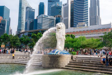 Singapur - 13 Haziran 2024: Merlion Parkı 'ndaki Merlion Fountain ve Singapur şehir silueti sabah mavi gökyüzü ile. Merlion Fountain, Singapur 'un en ünlü turistik yerlerinden biridir. Seyahat kavramı