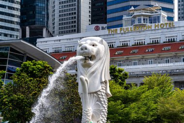 Singapur - 13 Haziran 2024: Merlion Parkı 'ndaki Merlion Fountain ve Singapur şehir silueti sabah mavi gökyüzü ile. Merlion Fountain, Singapur 'un en ünlü turistik yerlerinden biridir. Seyahat kavramı