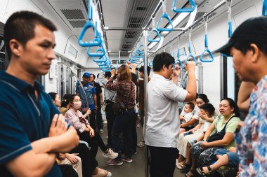 Ho Chi Minh şehri, Vietnam - 15 Aralık 2024: Vietnam 'da metro trenindeki insanlar. Metro vagonunun içi.