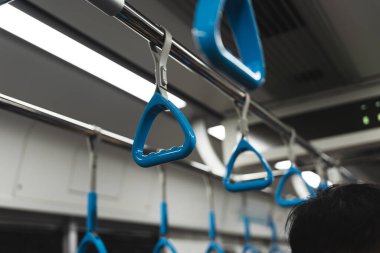 Metro ya da metro tırabzanı, mavi tırabzan tutan el.