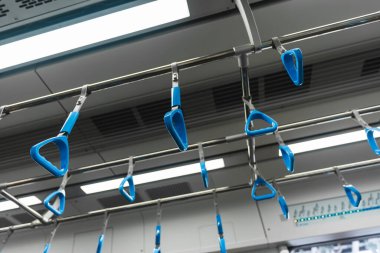 Metro ya da metro tırabzanı, mavi tırabzan tutan el.