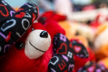 Bu stok fotoğrafı çeşitli kırmızı ayıcıklı yumuşak oyuncakları gösteriyor. Ayıların hepsi farklı boyutlarda ve şekillerde.