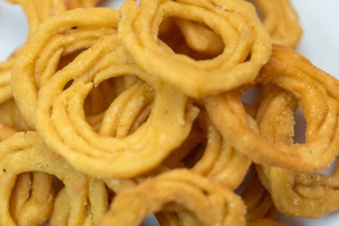 Beyaz arka planda izole edilmiş tereyağlı gevrek bir murukku 'nun yakın plan çekimi..