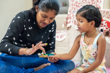 Bu resim, çocukların ellerini sarıya ve yeşile boyamış altın bilezik takan kızı anlatıyor.