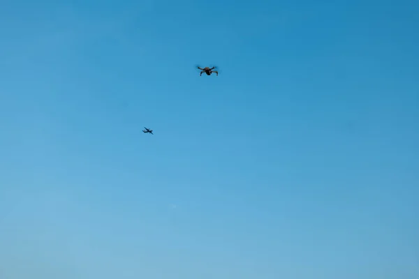 空中奇观犹如一架无人机和一架飞机优雅地在广阔的蓝天中翱翔 — 图库照片