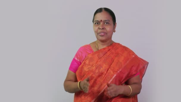 このビデオは 南インドの女性がカメラの前で平らな背景でVanakkamと言って弓についてです — ストック動画