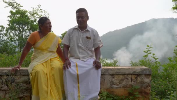 高齢者のインド人夫婦は 山の景色を楽しみながら 喜んでお互いに話しています 二人とも笑顔でお互いの会社を楽しんでいるようだ — ストック動画