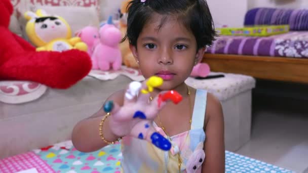 这个视频讲的是小女孩用五彩斑斓的绿色 红色和蓝色装饰手指填充物 — 图库视频影像