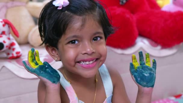 このビデオは小さな女の子の子供のショーの両方の手が描かれていました色緑と黄色と彼女は笑顔 — ストック動画