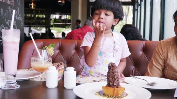 这段视频是关于小女孩在餐馆吃巧克力后舔手指的故事 — 图库视频影像