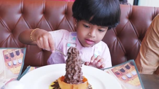 这段视频讲的是小女孩坐在妈妈身边 用勺子和华夫饼吃着巧克力 吃着白盘 — 图库视频影像