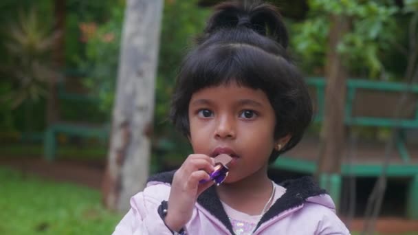 Молодая Девушка Улыбается Смеется Наслаждаясь Кусочком Шоколада Парке — стоковое видео