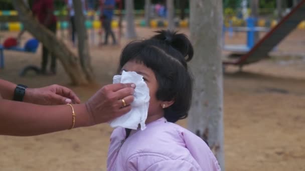 一个可爱的小女孩打喷嚏 而她的妈妈为她拿着一张纸巾 这个女孩穿着一件粉红色的衣服 — 图库视频影像