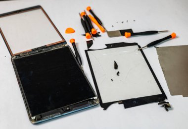 Bu stok resmi çeşitli araçlarla tableti tamir eden bir teknisyen içerir