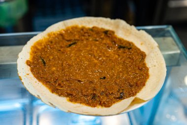 Bir altın-kahverengi dosa, krep gibi narin dış görünüşü yumuşak bir...