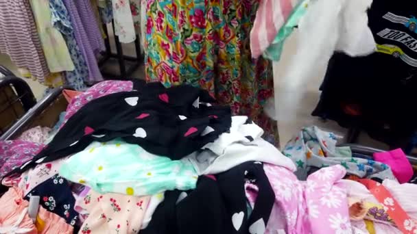 このビデオは 2024年3月2日のバンガロール市 カルナタカ国インドからのもので 明るく照らされた衣料品店で娘のための美しいドレスの価格タグを注意深く調べます — ストック動画
