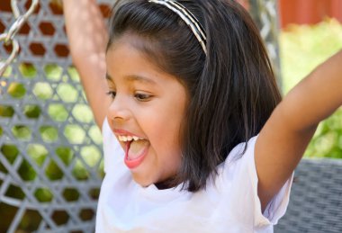 Çocuk parkında salıncakta oynayan Asyalı bir kızın portresi