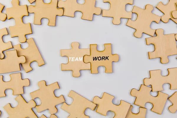 stock image This image depicts the concept of teamwork through jigsaw puzzle pieces fitting together on a white background.