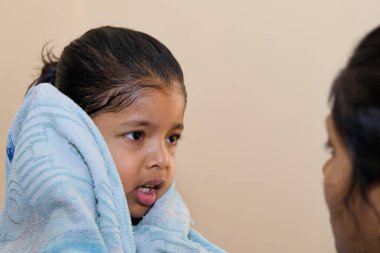 Sevecen bir anne, çocuğunu oynak bir banyodan sonra yumuşacık bir havluya sarar. Ebeveyn bakımını göstermek için mükemmel.